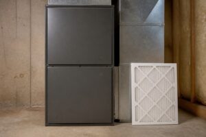 Closed residential gas furnace with a clean replacement filter nearby