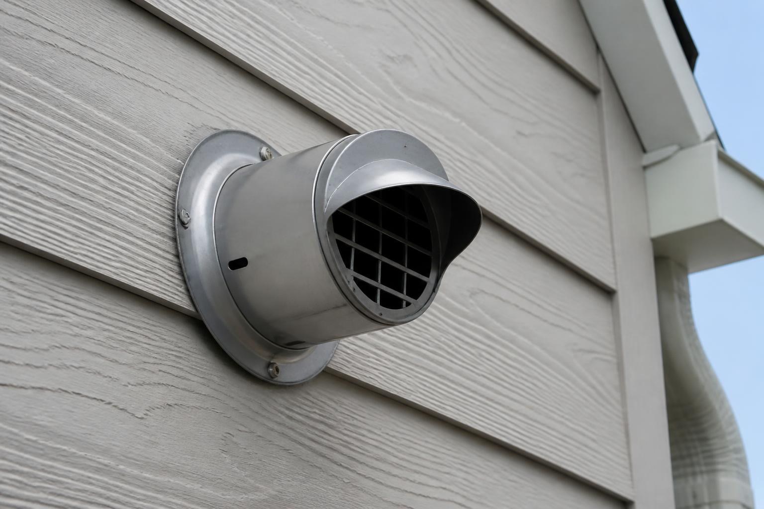 Exterior vent termination for a tankless water heater on a residential wall